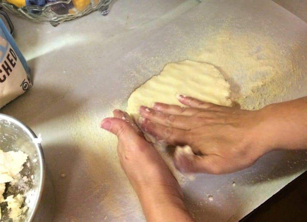 Pat dough into a circle with your fingers.
