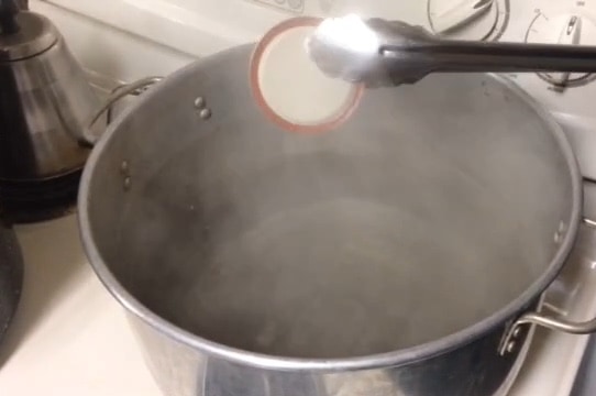 Dipping lids into boiling water