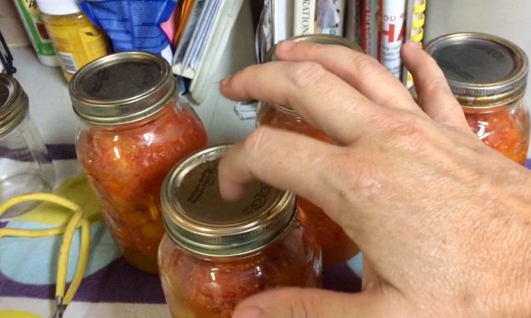 Checking for sealed jars of tomatoes.  