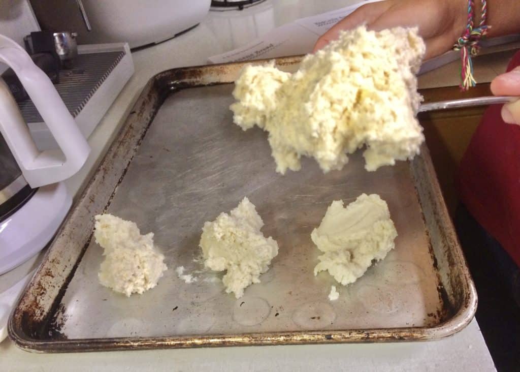 Spoon dropping biscuit dough onto a cookie sheet